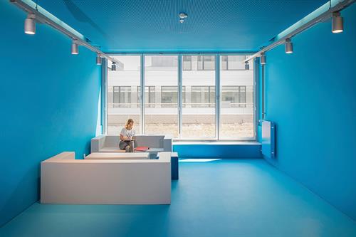 This picture shows building fife of the new campus Derendorf of Hochschule Düsseldorf. The front of the building is of glass and steel, indoors you see blue elements like the stairs and some walls. This building includes the Faculty of Electrical Engineering & Information Technology and the Faculty of Mechanical and Process Engineering.